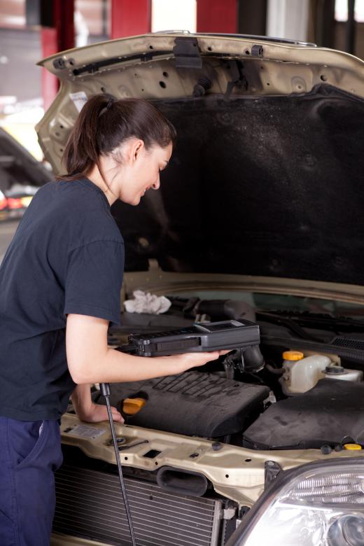 A mechanic tuning up a car.